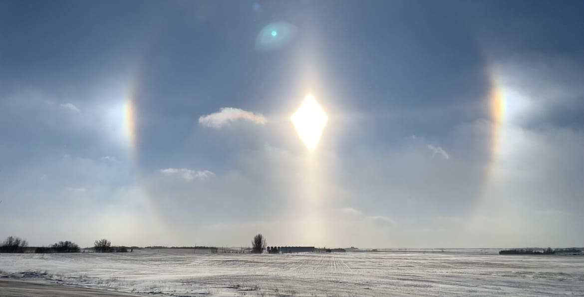 Midday sun dogs on the Canadian prairies. Winter can be long, cold, and bleak. Winter holidays' original purpose in the North was possibly to brighten up and add warmth to the dark frigid winters.
