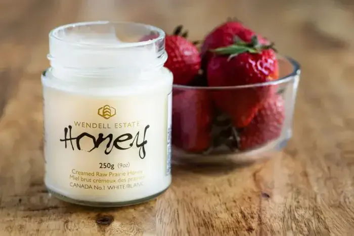 Premium unpasteurized raw honey sweetens fresh strawberries